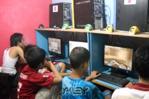 Indonesian kids playing online computer games at an internet cafe in Indonesia.