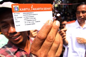 Indonesian man holding up Jakarta Health Card (KJS) launched by Govornor Jokowi.